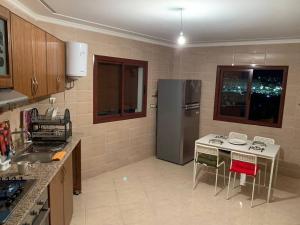 una cocina con refrigerador y una mesa con sillas en appartement équipé, en Tánger 9 fotos más