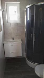 a bathroom with a shower and a sink at Ośrodek Wypoczynkowy Domki Nadika in Bobolin