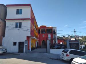 Departamentos velasco في تيخوانا: مجموعة مباني فيها سيارات متوقفة في موقف للسيارات