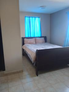 a bedroom with a bed and a blue window at Departamentos velasco in Tijuana