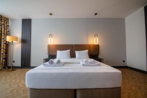 a bedroom with a large bed with two towels on it at V Center Hotel in Trabzon