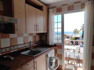 cocina con fregadero y lavavajillas junto a una ventana en Apartamento Delfín, en Mojácar