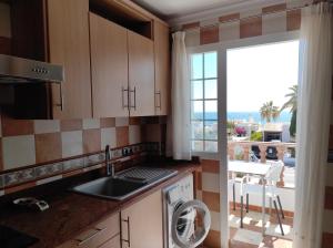 a kitchen with a sink and a dishwasher next to a window at Apartamento Delfín in Mojácar