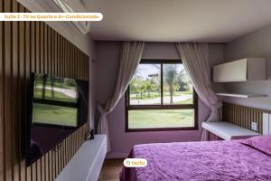 a bedroom with a purple bed and a window at Térreo com churrasqueira no VG Sun por Tactu in Cumbuco