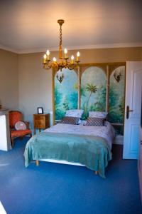 um quarto com uma cama grande e uma pintura na parede em Chambre au Château de St-Pierre-Brouck em Saint-Pierre-Brouck