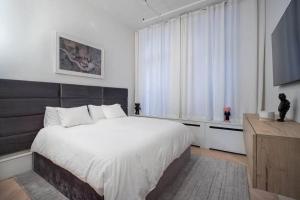 a bedroom with a large bed and a large window at Luxurious 2 Bedroom Loft Entire Apartment in New York