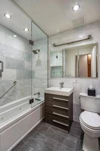 La salle de bains est pourvue de toilettes, d'un lavabo et d'une douche. dans l'établissement Luxurious 2 Bedroom Loft Entire Apartment, à New York