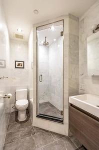 a bathroom with a shower and a toilet and a sink at Luxurious 2 Bedroom Loft Entire Apartment in New York