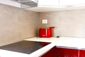 un apparecchio rosso seduto sopra un bancone della cucina di Le Terrazze sulle Eolie a Marina di Caronia
