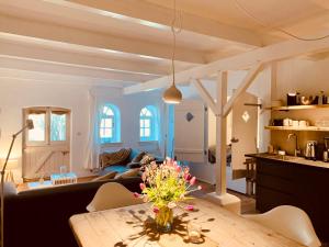 - un salon avec une table et des fleurs dans l'établissement Landhaus Börmoos, à Steinberg