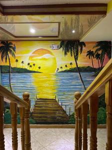 a mural of a beach with palm trees on a wall at Hotel Las Guacamayas Guatapé in Guatapé