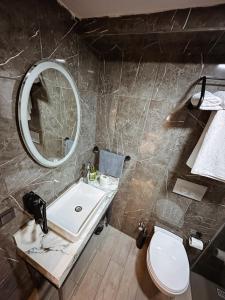 a bathroom with a sink and a mirror and a toilet at Hostel Amasra in Bartın