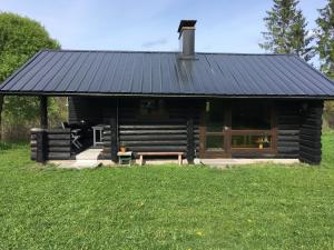 a log cabin with a bench in the grass at Valkolan kartanon saunatupa, yksi huone ja sauna in Hankasalmi