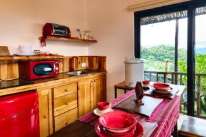 une cuisine avec une table et un four micro-ondes rouge dans l'établissement Hotel Casa Realeza, à Antigua Guatemala