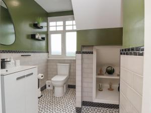 baño con aseo y pared verde en The Wheatley, en Ilkley