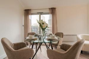 a dining room with a glass table and chairs at Inicio Stays - Cosy Penthouse in the City Centre - Free Secure Parking - With City & Canal Views - Wrap Around Balcony - Netflix in Birmingham