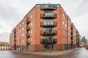 a brick building with balconies on the side of it at Inicio Stays - Cosy Penthouse in the City Centre - Free Secure Parking - With City & Canal Views - Wrap Around Balcony - Netflix in Birmingham