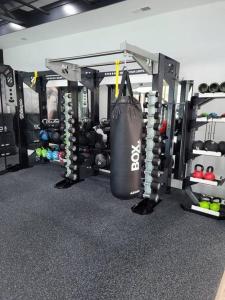 un gimnasio con una bolsa de boxeo colgando de un estante en South Charlotte’s Cozy & Modern en Charlotte