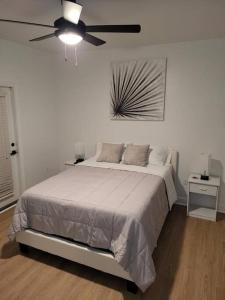 a white bedroom with a bed and a ceiling fan at South Charlotte’s Cozy & Modern in Charlotte