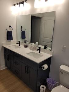 a bathroom with two sinks and a large mirror at South Charlotte’s Cozy & Modern in Charlotte