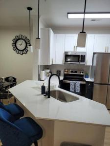 a kitchen with a sink and a stove top oven at South Charlotte’s Cozy & Modern in Charlotte