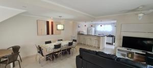uma sala de estar com mesa e cadeiras e uma cozinha em Casa Melo 4 em Ubatuba