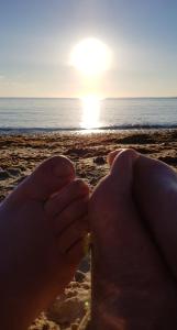 eine Person mit einem Glas Bier am Strand in der Unterkunft Cwtch, White Horse, Seal Bay Resort in Selsey