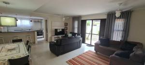 uma sala de estar com dois sofás e uma cozinha em Casa Melo 4 em Ubatuba