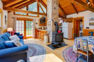 a living room with a blue couch and a stove at Historic Morrisdale Area Cabin with Deck and Fireplace 