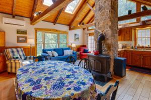 een woonkamer met een tafel en een fornuis bij Historic Morrisdale Area Cabin with Deck and Fireplace 