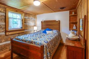 1 dormitorio con 1 cama en una cabaña de madera en Historic Morrisdale Area Cabin with Deck and Fireplace, 