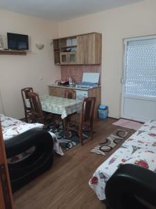 Zimmer mit einem Tisch und Stühlen sowie einer Küche in der Unterkunft Krapce - Lake View Apartments in Star Dojran