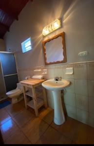 a bathroom with a sink and a mirror and a toilet at Hotel y Balneario Villa Paraíso in Catacamas