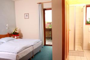 Un dormitorio con una cama y un balcón. en Hotel & Gasthof zum Rödelseer Schwan, en Rödelsee