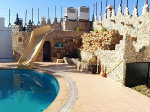 een zwembad met een glijbaan voor een gebouw bij Villa piscine Agadir in Agadir