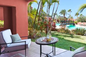 a patio with a table and chairs and a pool at The Ritz-Carlton Tenerife, Abama in Guía de Isora