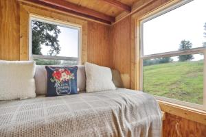 a bedroom with a bed and two windows at Pendergrass Tiny Home Cabin on Pond with Fire Pit! in Braselton