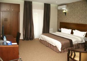 a hotel room with a large bed and a desk at Old Metekhi Hotel in Tbilisi City