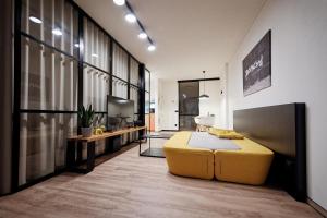 ein Wohnzimmer mit einem gelben Sofa und einem TV in der Unterkunft Apartman Aper in Znojmo