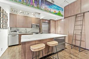 una cocina con barra y dos taburetes. en Furnished and Meticulously Renovated 3-bedroom, 2-bathroom Loft en Nueva York