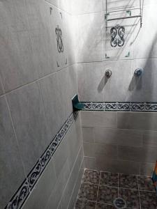 y baño con ducha y suelo de baldosa. en Colombia 147, en Puerto Vallarta