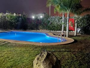a small swimming pool in a yard at night at Villa avec Piscine, Terrain de Foot et Aire de Jeux pour Enfants in Bir Jedíd Saint-Hubert
