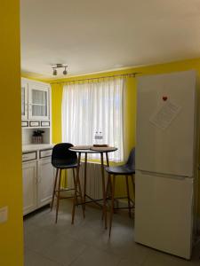 a kitchen with a table and chairs and a refrigerator at Dārza māja in Liepāja +16 photos