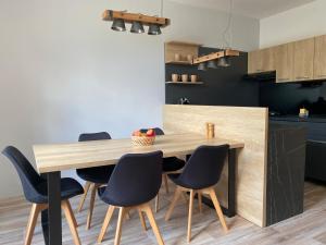 a kitchen with a wooden table and chairs at Apartmány Havířská Žacléř, Krkonoše in Žacléř