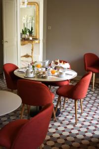 a dining room with a table and red chairs at Domaine de l'Ermitage in Berry-Bouy