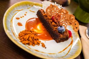 une assiette avec un morceau de gâteau et une myrtille dans l'établissement Grande Hotel Thermas Nature & SPA, à Termas de São Pedro do Sul