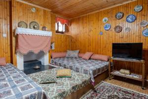 a room with two beds and a fireplace and plates on the wall at Monodendri Vintage House in Monodendri