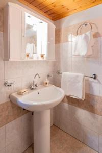 a white bathroom with a sink and a mirror at Monodendri Vintage House in Monodendri