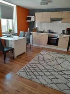 cocina con mesa, sillas y alfombra en Ferienwohnung Gisela, en Jockgrim