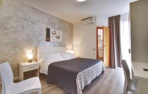 um quarto de hotel com uma cama, uma secretária e uma cadeira em Hotel Augusta em Caorle